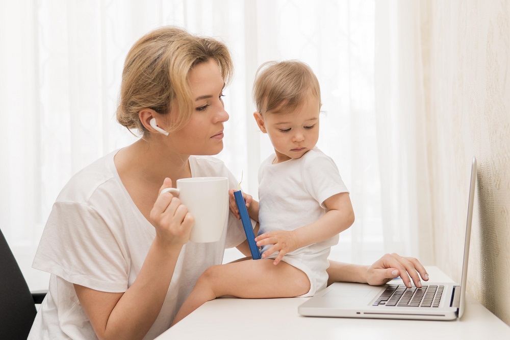 Юлия/замена/mid-shot-mother-drinking-coffee-baby-desk.jpg